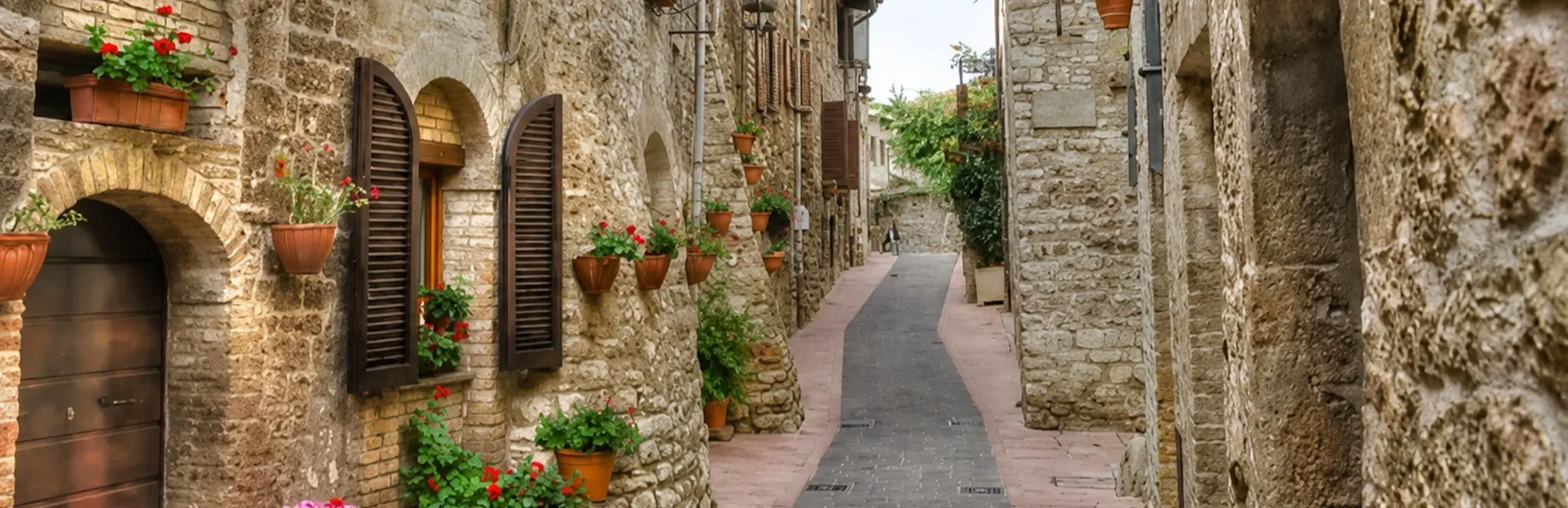 Flower-lined medieval stone alley in Assisi on the Saint Francis audio tour