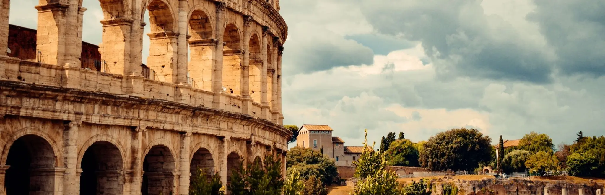 The Colosseum and ruins of ancient Rome beneath a cloudy sky